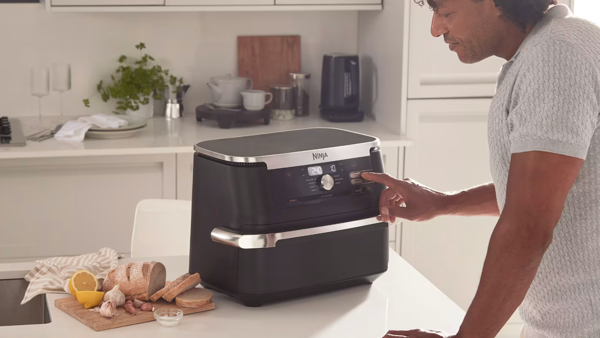 Mężczyzna korzysta w białej kuchni z Ninja AF500EU
