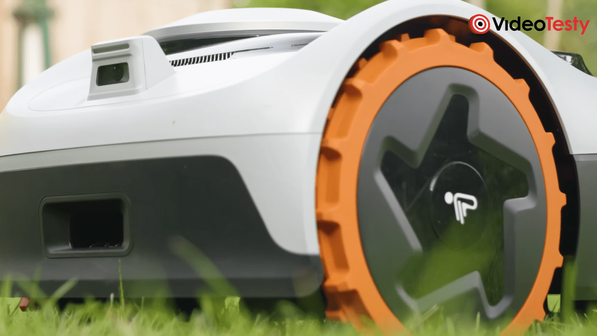 Zbliżenie na pomarańczowe koła szaro-białej kosiarki Segway Navimow i105E