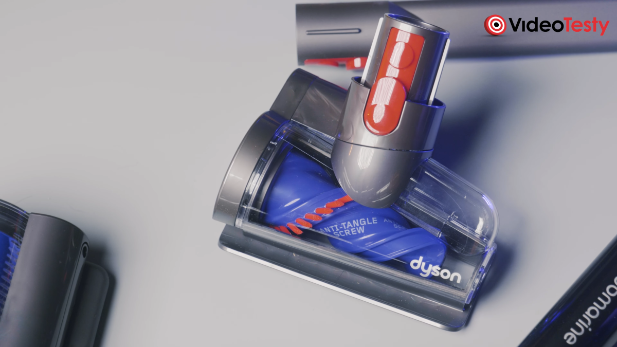 Mini-elektroszczotka Dyson V15s Detect Submarine na szarym tle, wewnątrz szaro-przezroczystej obudowy znajduje się niebieski element-spirala zwężający w jedną stronę