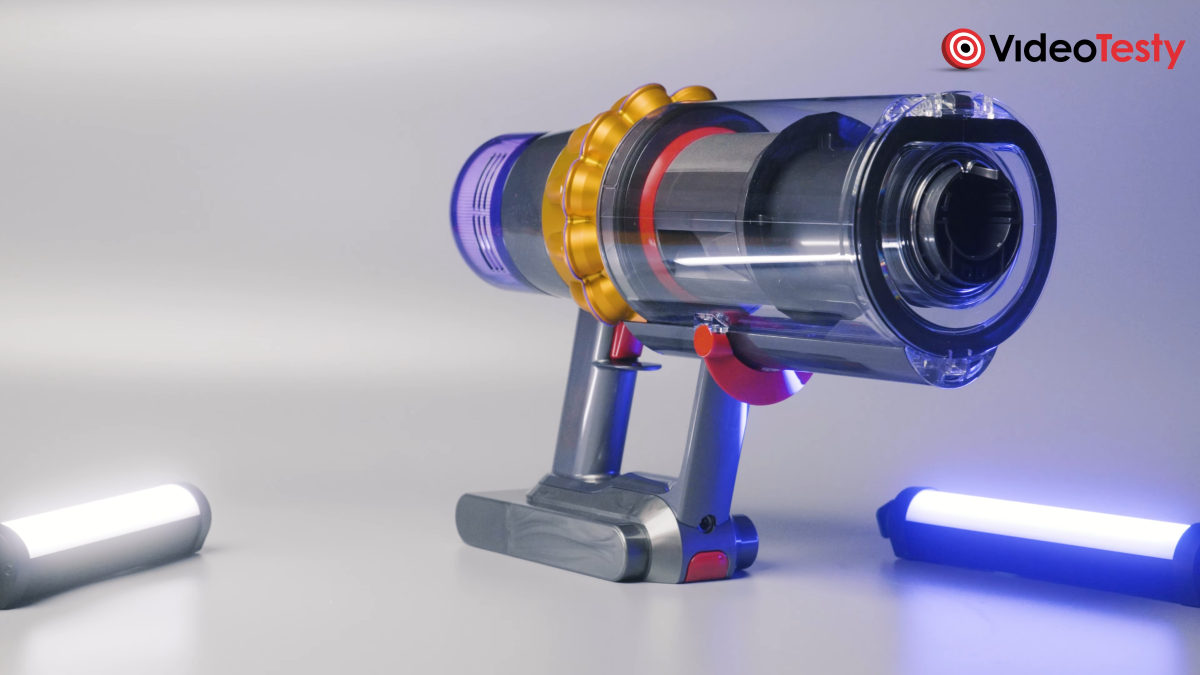 Dyson V15s Detect Submarine na szarym tle, odkurzacz jest szaro-czerwono-niebieski z żółtym połyskliwym elementem blisko rączki