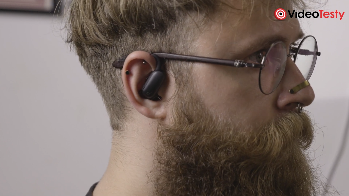 Zbliżenie na mężczyznę w okularach z czarnymi słuchawkami Soundcore AeroFit 2 Pro