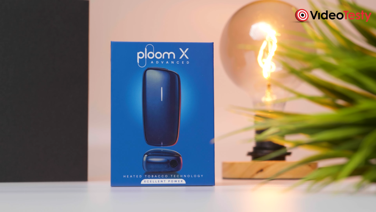 Opakowanie Ploom X Advanced obok żarówki na biało-czarnym tle