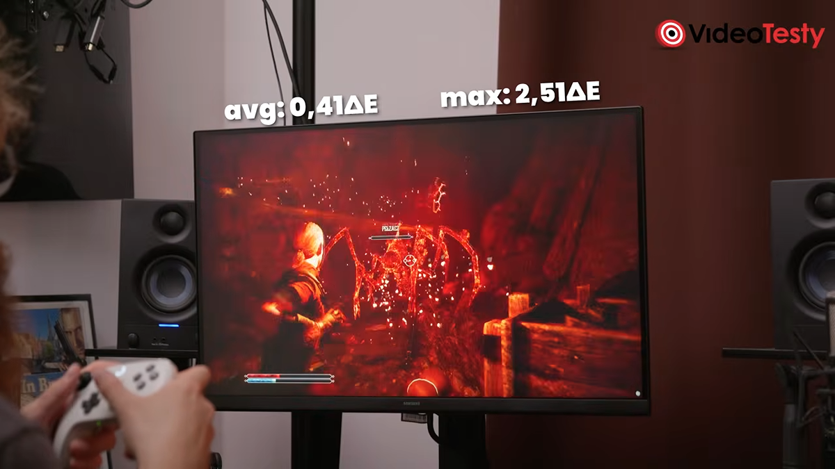 Mężczyzna gra na monitorze przy pomocy pada w Gothic Remake. Nad monitorem widać wyniki ekranu po kalibracji
