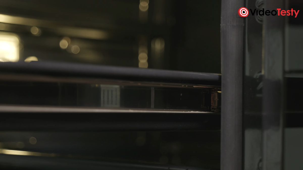 Zbliżenie na stalowe prowadnice teleskopowe w piekarniku