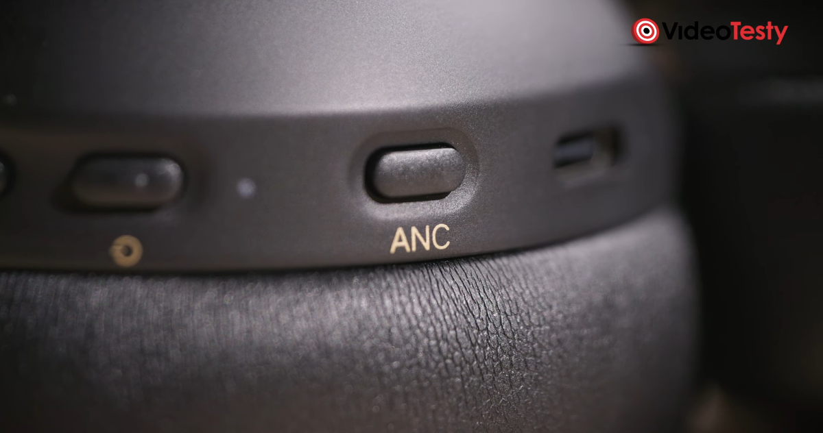 Zbliżenie na przycisk ANC na czarnych słuchawkach