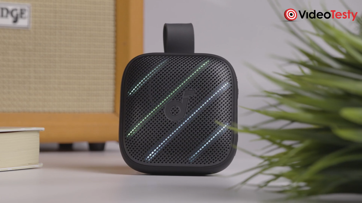 Soundcore Boom Go 3i: czarny głośnik bluetooth z RGB widziany na tle wzmacniacza