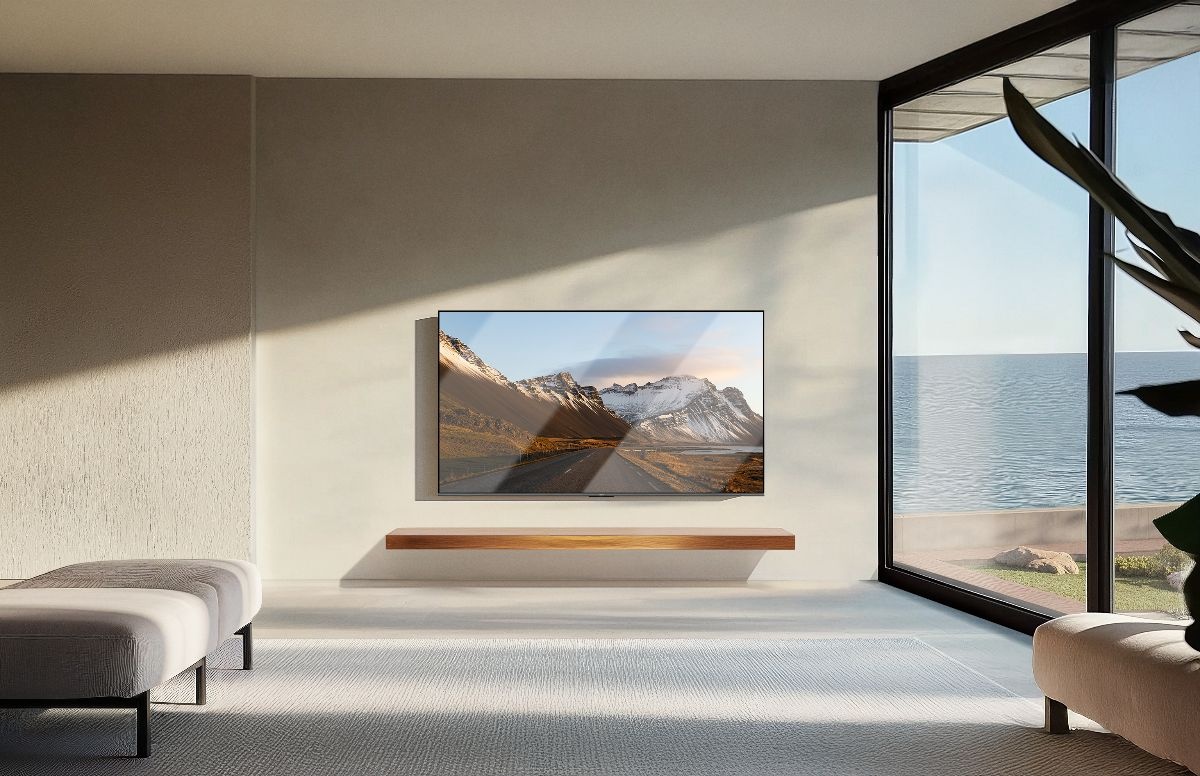 Telewizor Xiaomi S Pro Mini LED 2026 znajdujący się w słonecznym salonie na szarej ścianie. Po prawej jest okno, rzucające światło pod kątem na telewizor