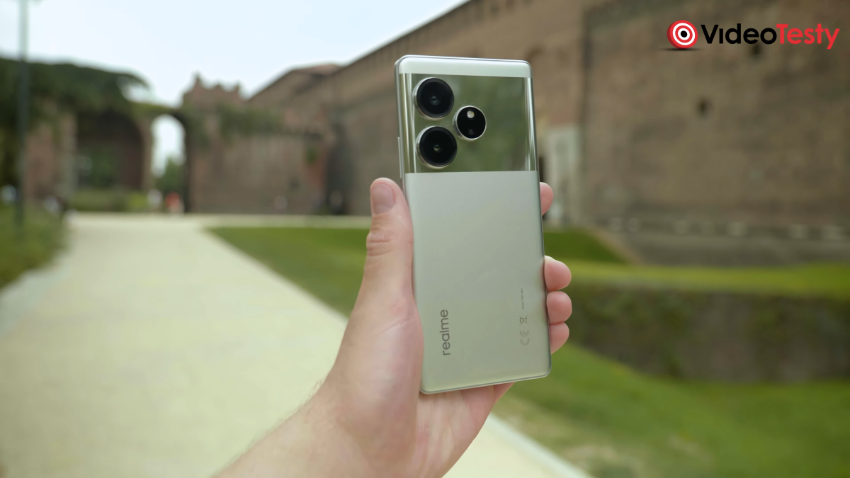 Realme GT 6 w rękach na tle ścieżki
