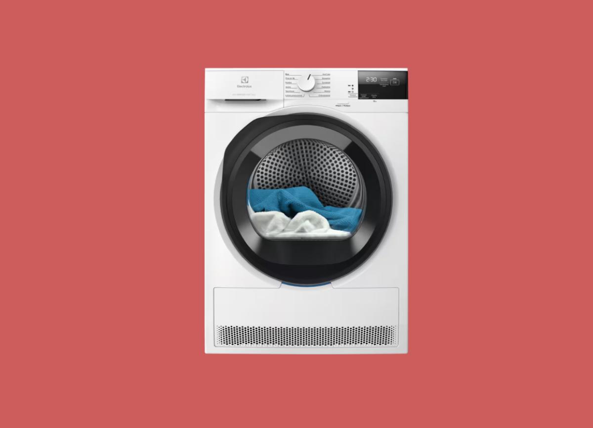 Biała suszarka Electrolux EW6D285YP na pastelowo-czerwonym tle. Ma czarne przeszklone drzwi, przez które widać niebieskie i białe ciuchy
