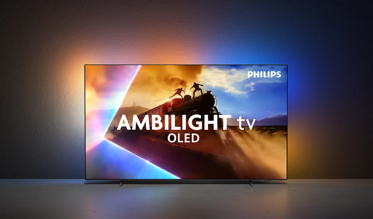 Widok na telewizor Philips 55OLED770/12 w ciemnym pomieszczeniu. Ściana za nim jest rozświetlona w kolorach odpowiadających temu, co jest na ekranie