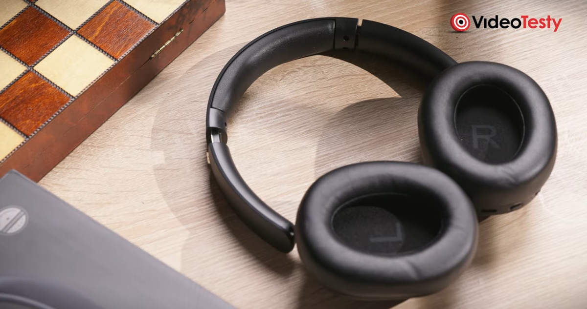 Zbliżenie na Czarne słuchawki koło szachownicy na jasnym stole