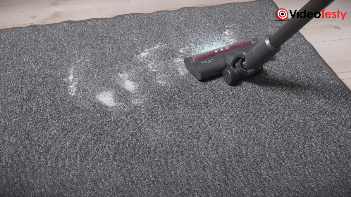 Widok na zbieranie odkurzaczem mąki z szarego dywanu